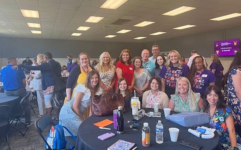 A large group of staff members gathered around a table