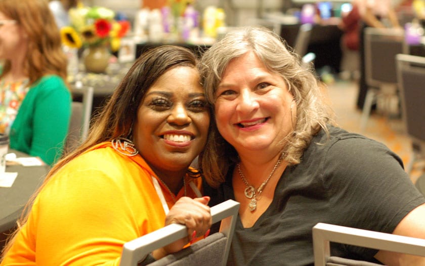 Two staff members smiling for a photo