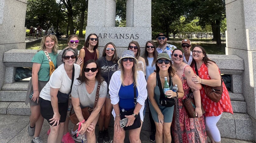 A group of Arkansas Connections Academy staff posing together in front of a monument in Washington D.C.