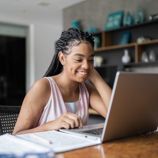 A high school student studying on her laptop