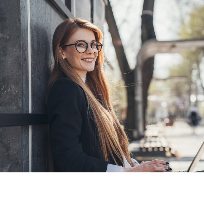 Professional young woman using a laptop outside