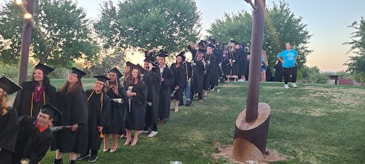 ACA students in their cap and gown preparing to walk