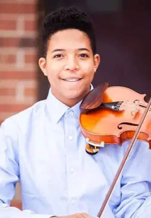 Leon holding a violin smiling