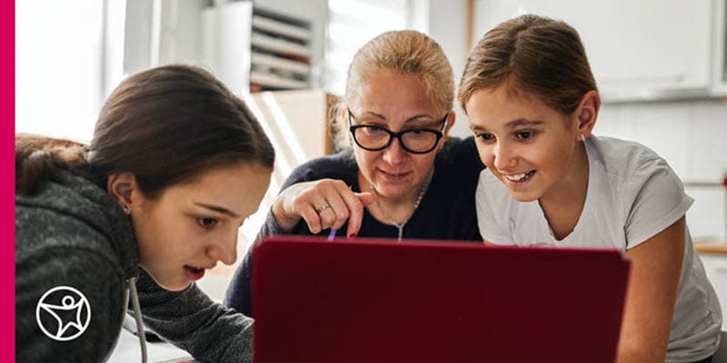 Mother and two daughters researching on laptop how much does online high school cost.