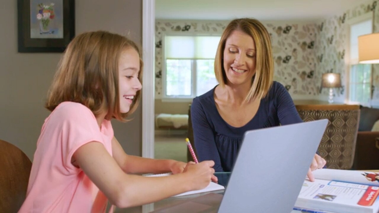 Young student and her learning coach mom working on an online class together